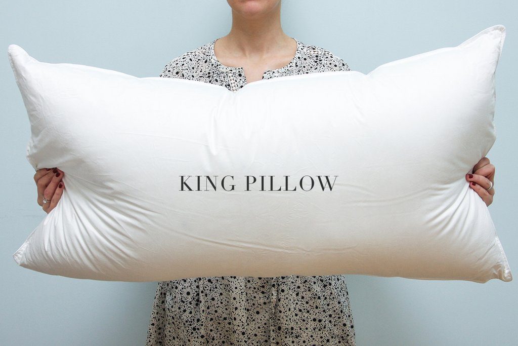 a woman holding a king sized pillow