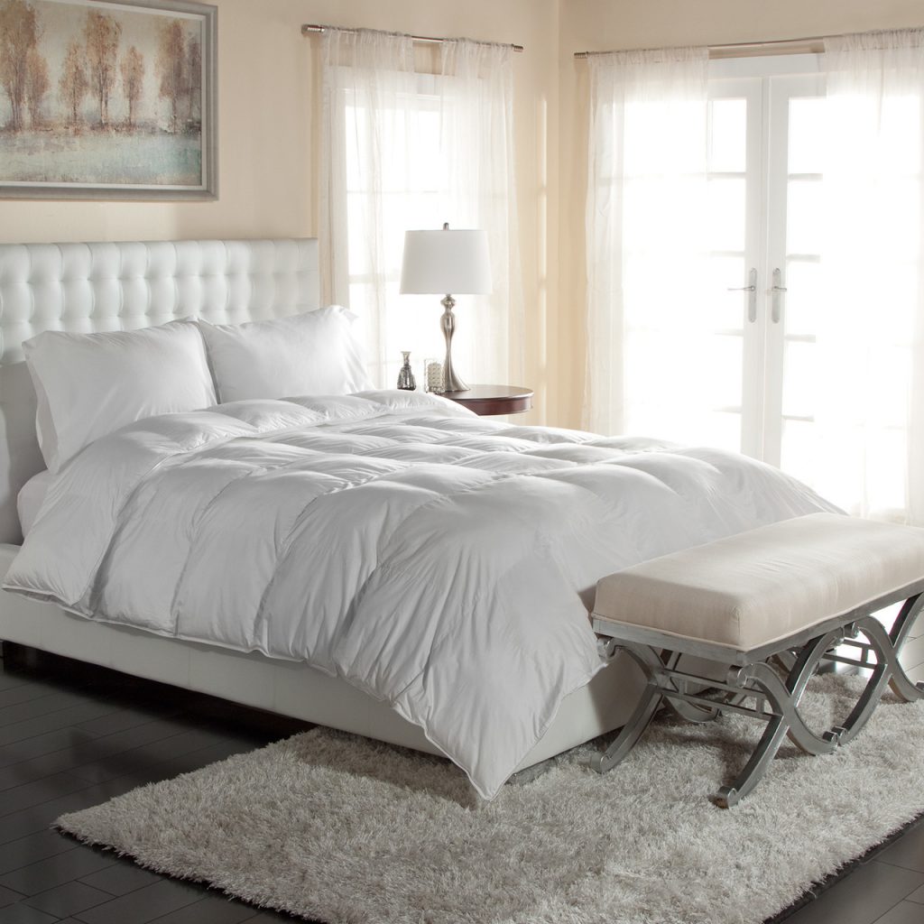 a white comforter on top of a bed
