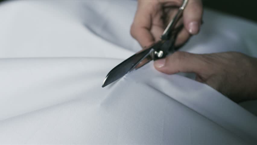 a woman cutting fabric with scissors
