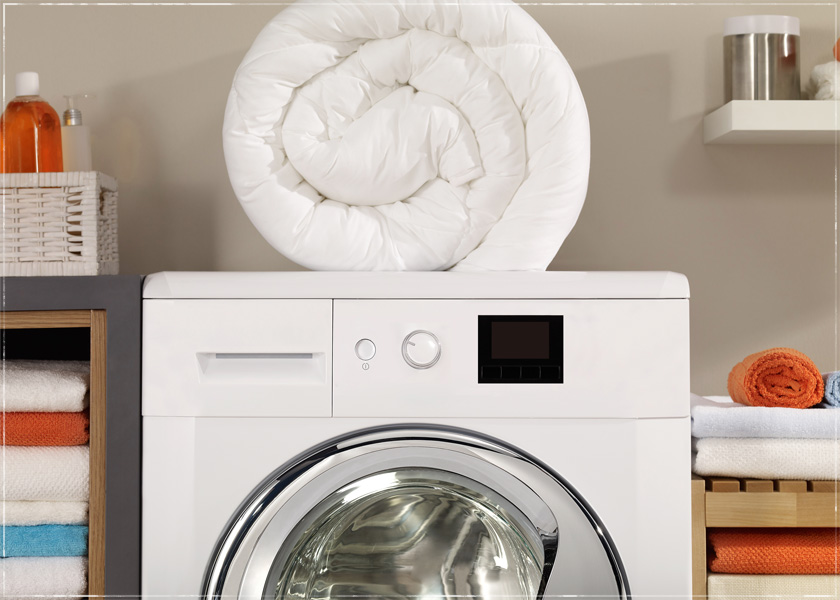 a comforter folded up on top of a washing machine