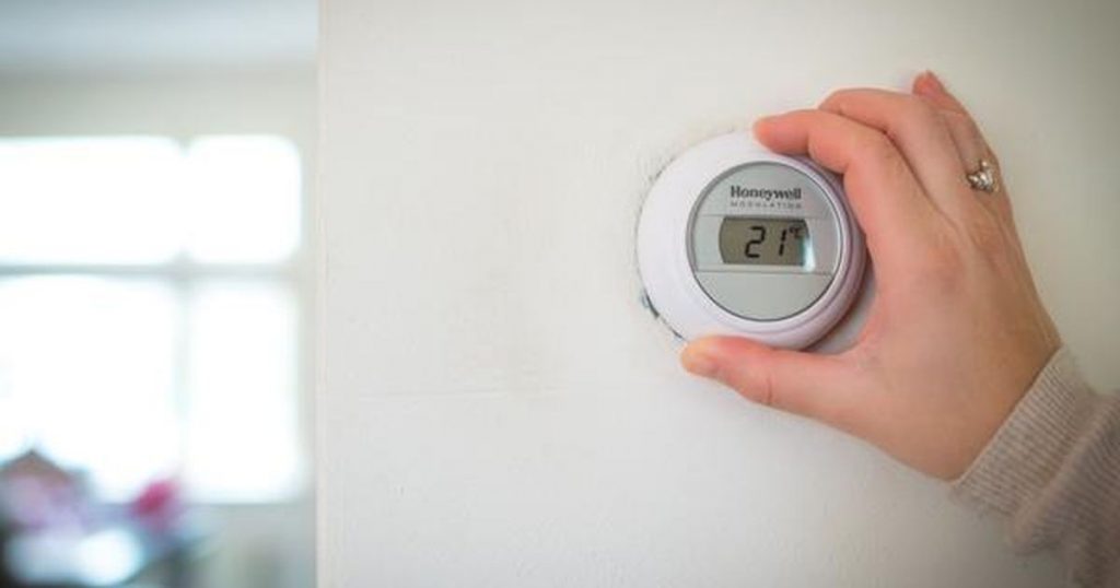 a man moving the thermostat dial