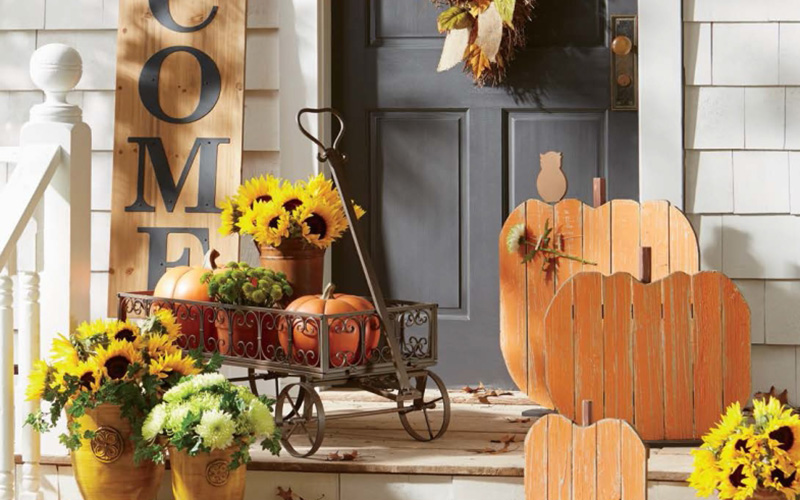 a porch decorated with Fall decorations