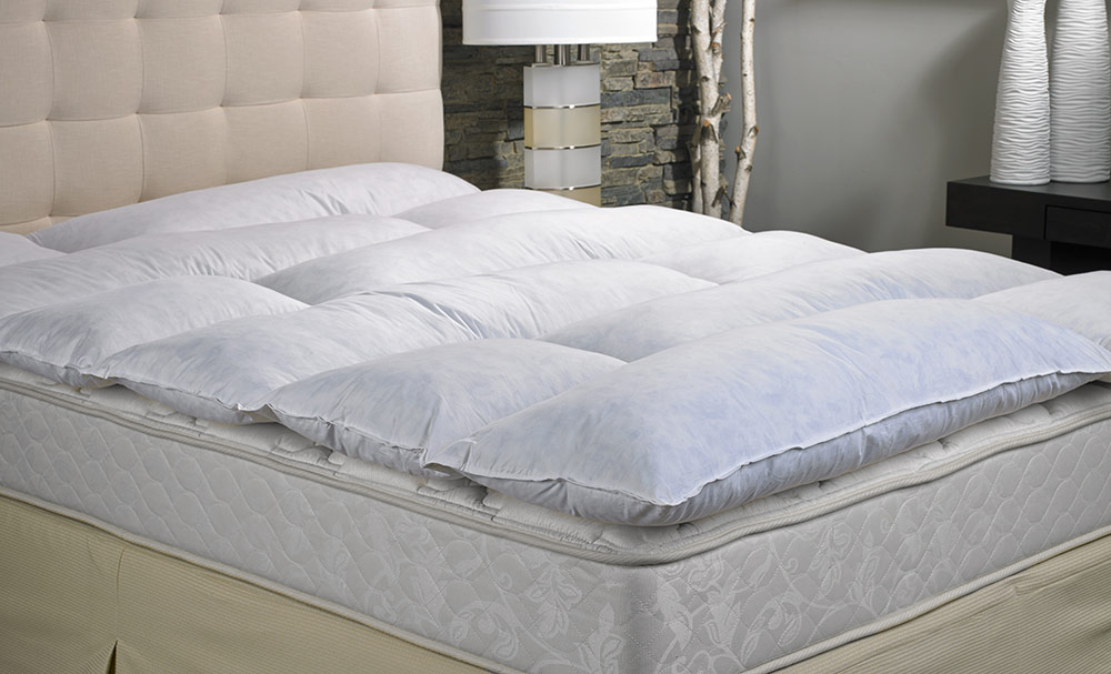 a featherbed placed on top of a mattress