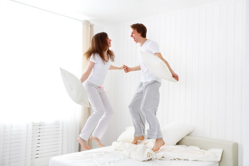 a couple jumping on a bed