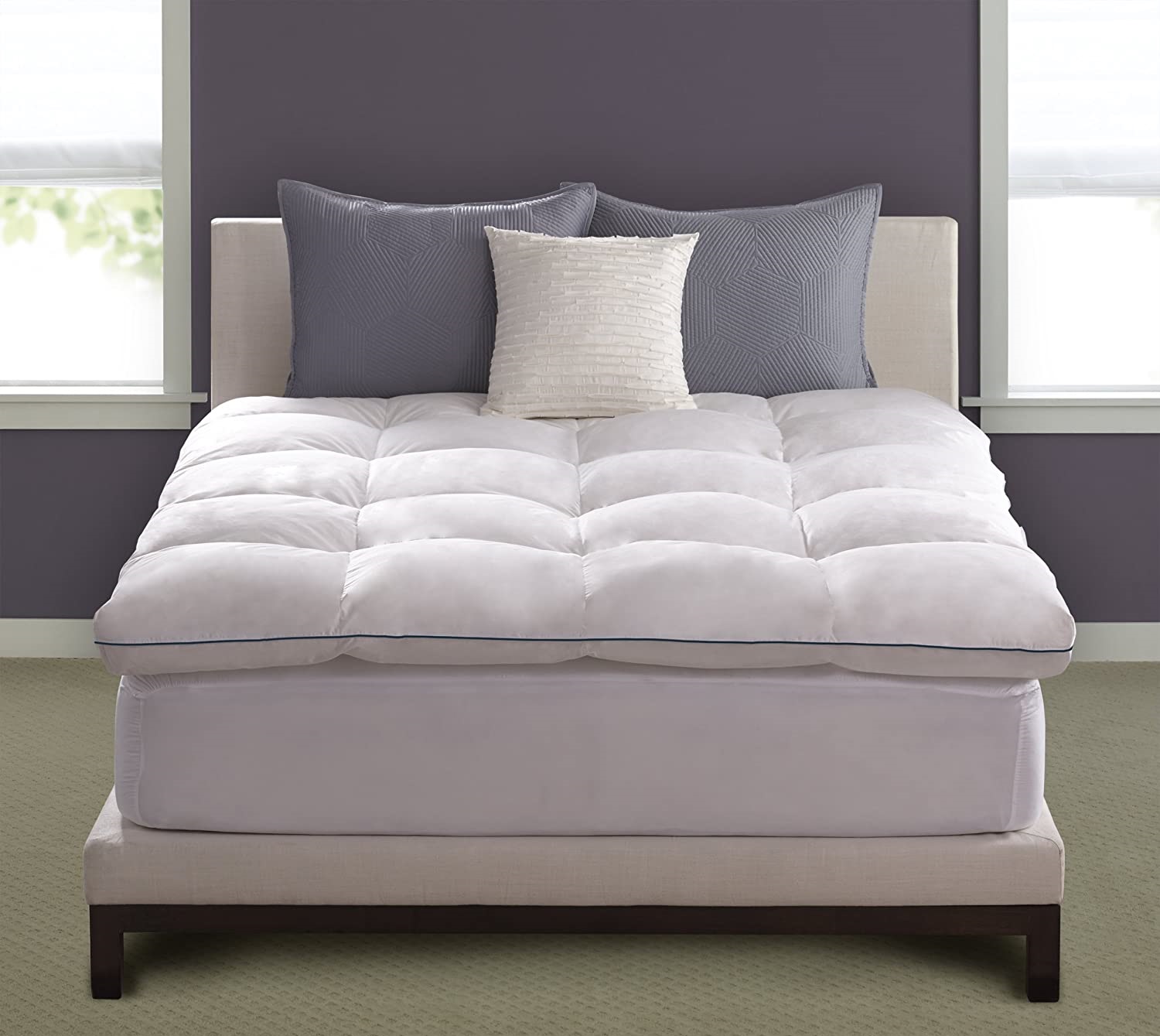 a white featherbed from Pacific Coast bedding with blue piping around the edges