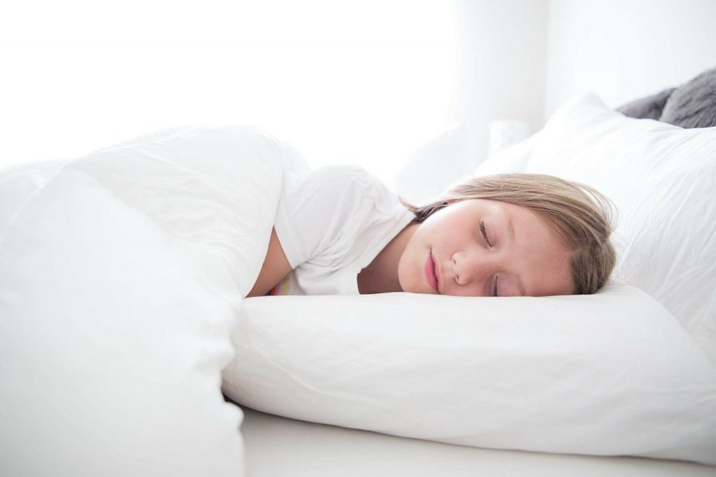 a girl sleeping on a Restful Nights Trillium pillow