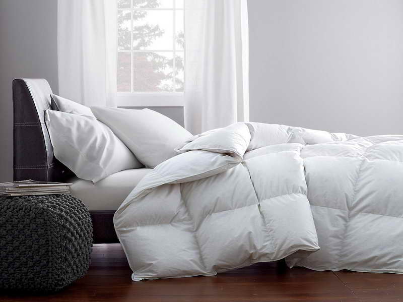 a comforter on a bed, shown from side view