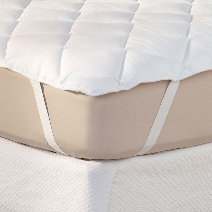 a mattress pad strapped around the corner of a mattress