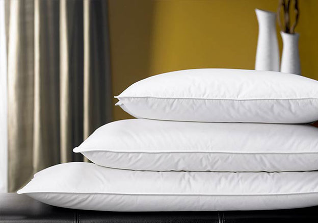a stack of pillows in a Westin Hotels bedroom