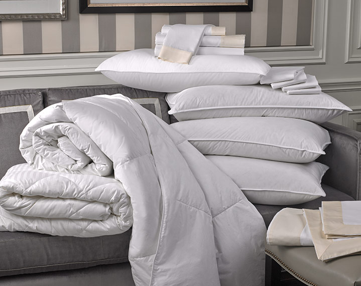 comforters, pillows, sheets, and duvet covers on a couch