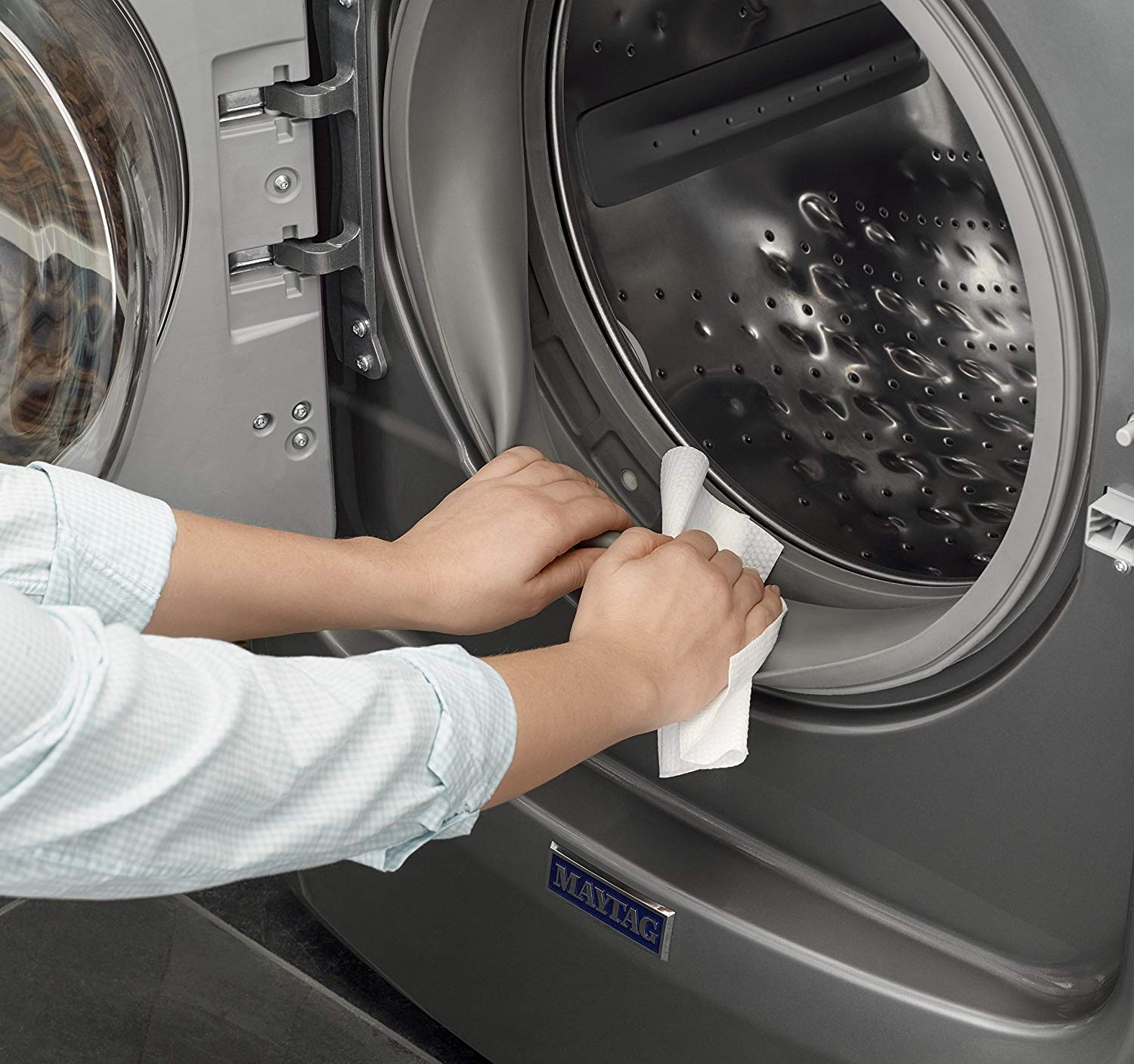 a woman using an Affresh washing machine wipe to clean her machine