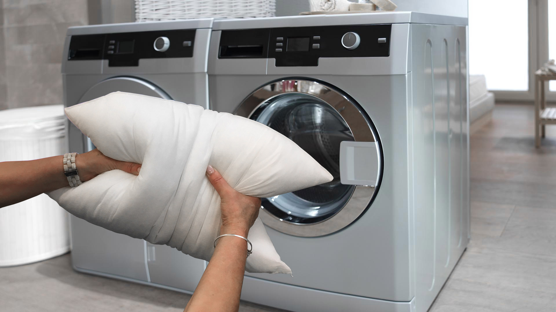 a pillow being placed inside of a washing machine