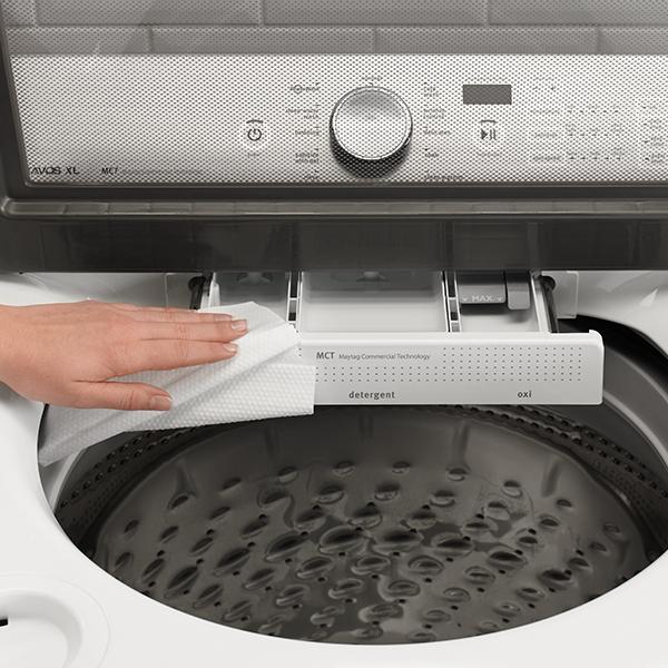 a woman cleaning the detergent tray of her washing machine