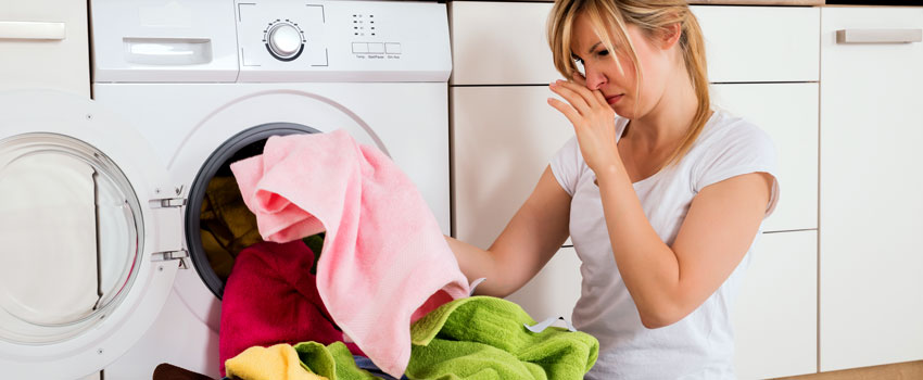 a disgusted woman because her laundry smells funky