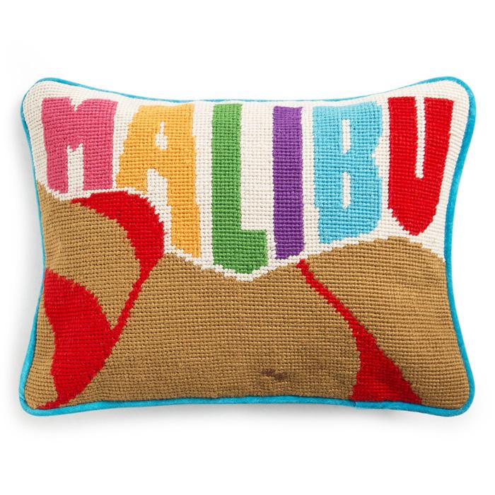 a Malibu decorative pillow featuring a woman in a red bikini