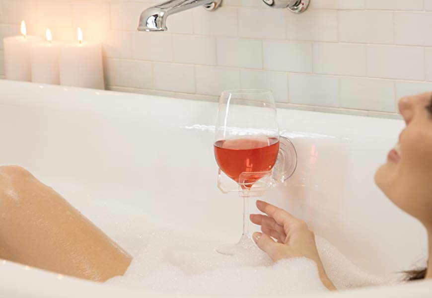 a woman enjoying a glass of wine in the bath