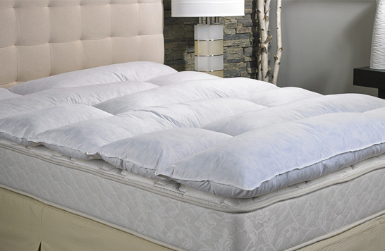 a featherbed on top of a mattress