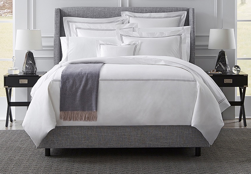 A hotel bed featuring Sferra Grande Hotel bedding products