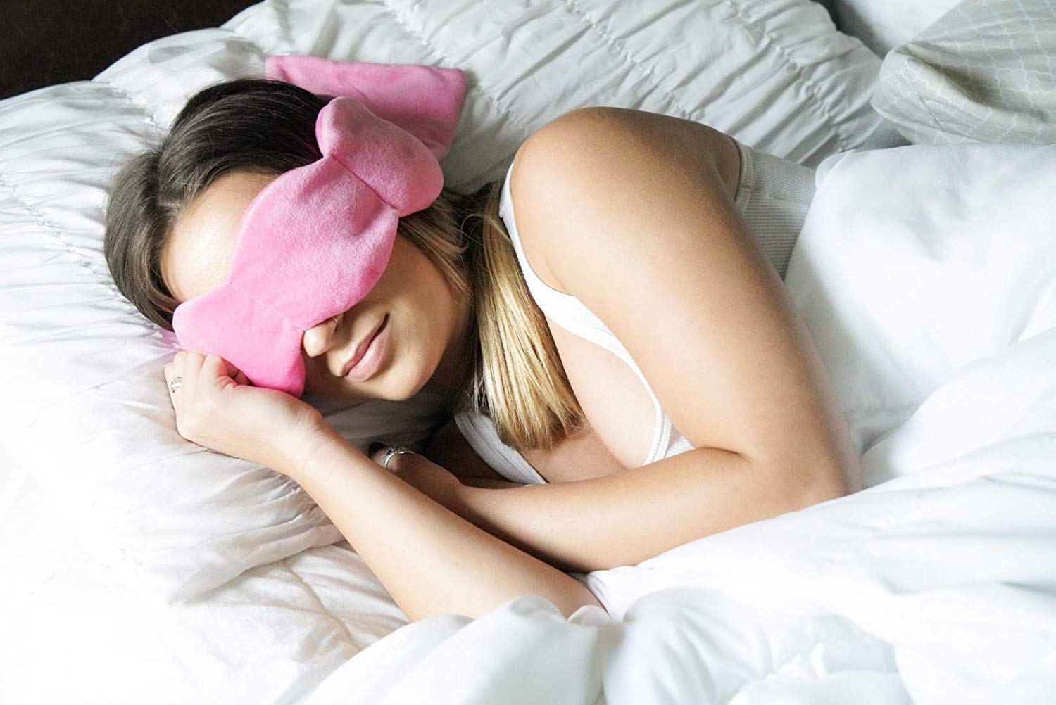 a woman sleeping on her side with a weighted sleep mask