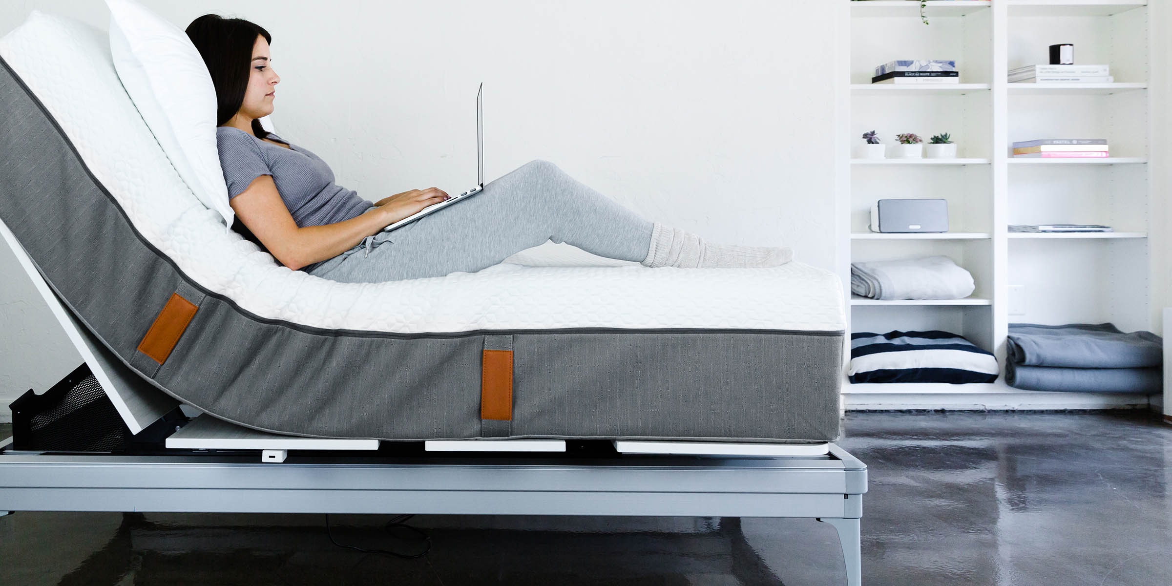 a woman laying on top of an adjustable mattress