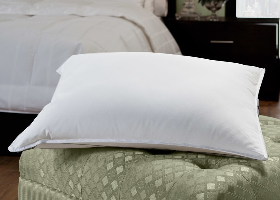 an Enviroloft pillow on top of an ottoman in a hotel room