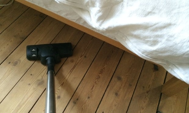 a person vacuuming under a bed
