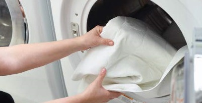 a woman pulling laundry out of a washing machine