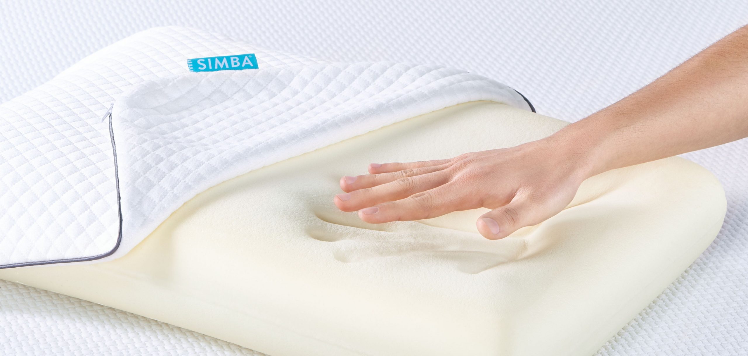 a woman pressing her hand into a memory foam pillow