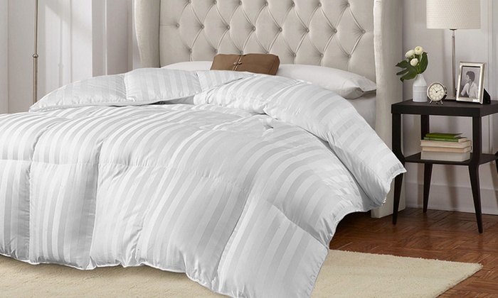 a white striped comforter on a bed
