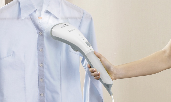 a woman steaming a garment with a handheld steamer
