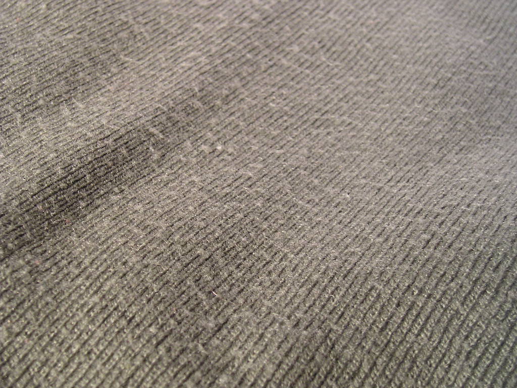 grey colored fabric that is covered in fuzz and pilling.