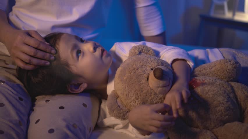 a child in bed with a teddy bear