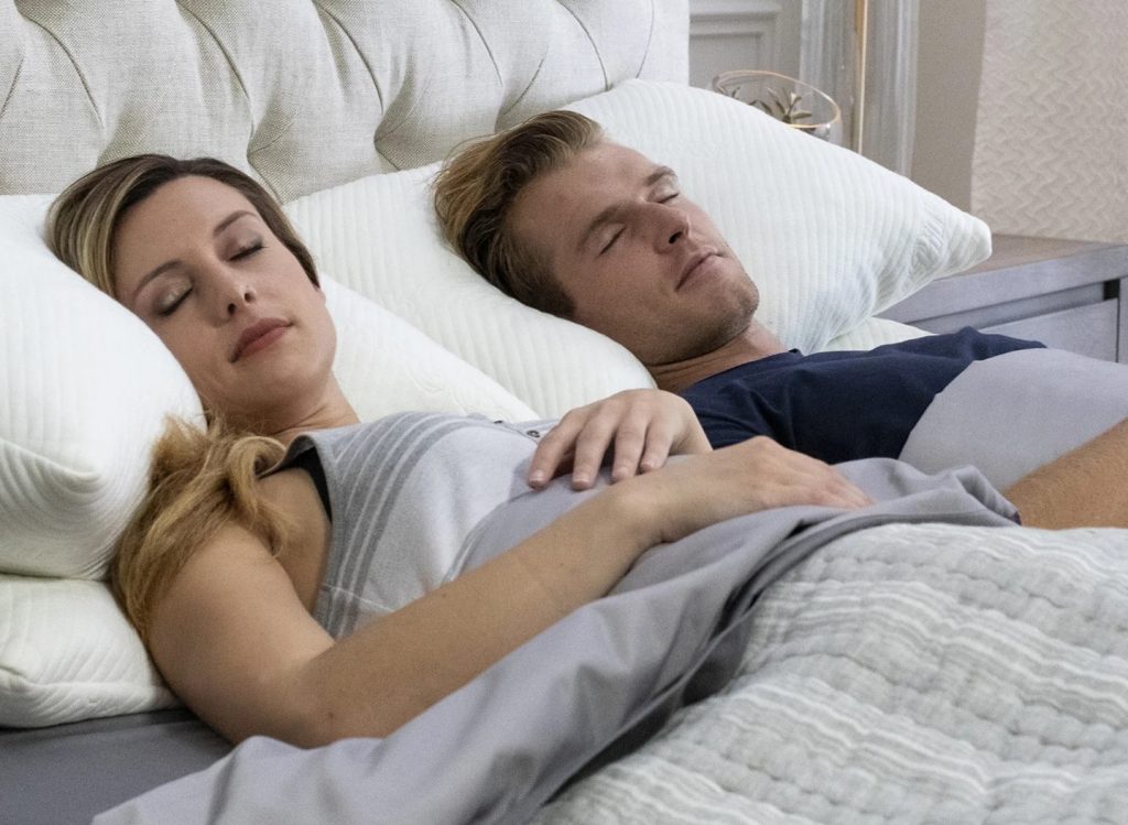 a couple sleeping in bed with CBD pillows