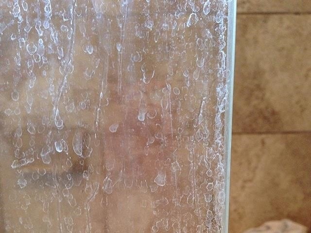 shower doors covered in water stains