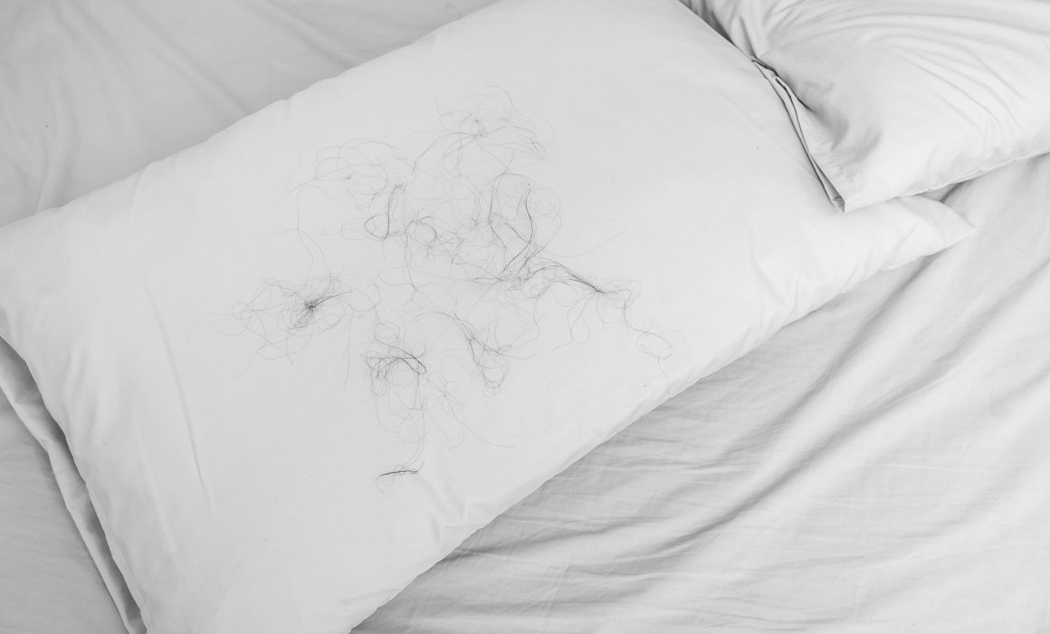 A pillowcase covered in loose strands of hair