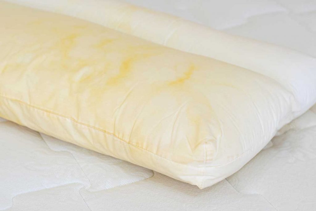 a while bed pillow with yellow staining all over