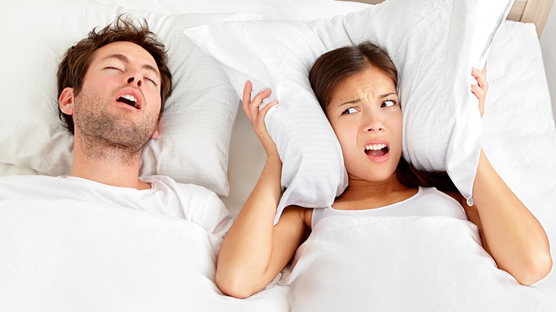 a woman frustrated in bed because of her partner is snoring