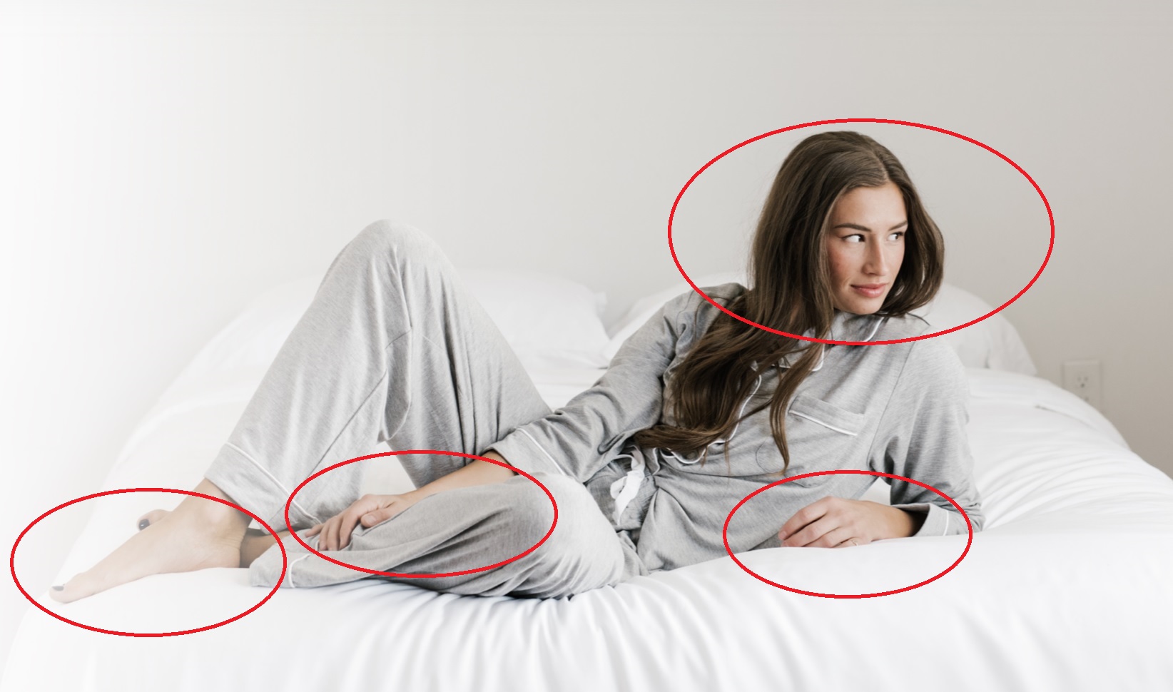 a woman wearing pajamas and laying in bed 