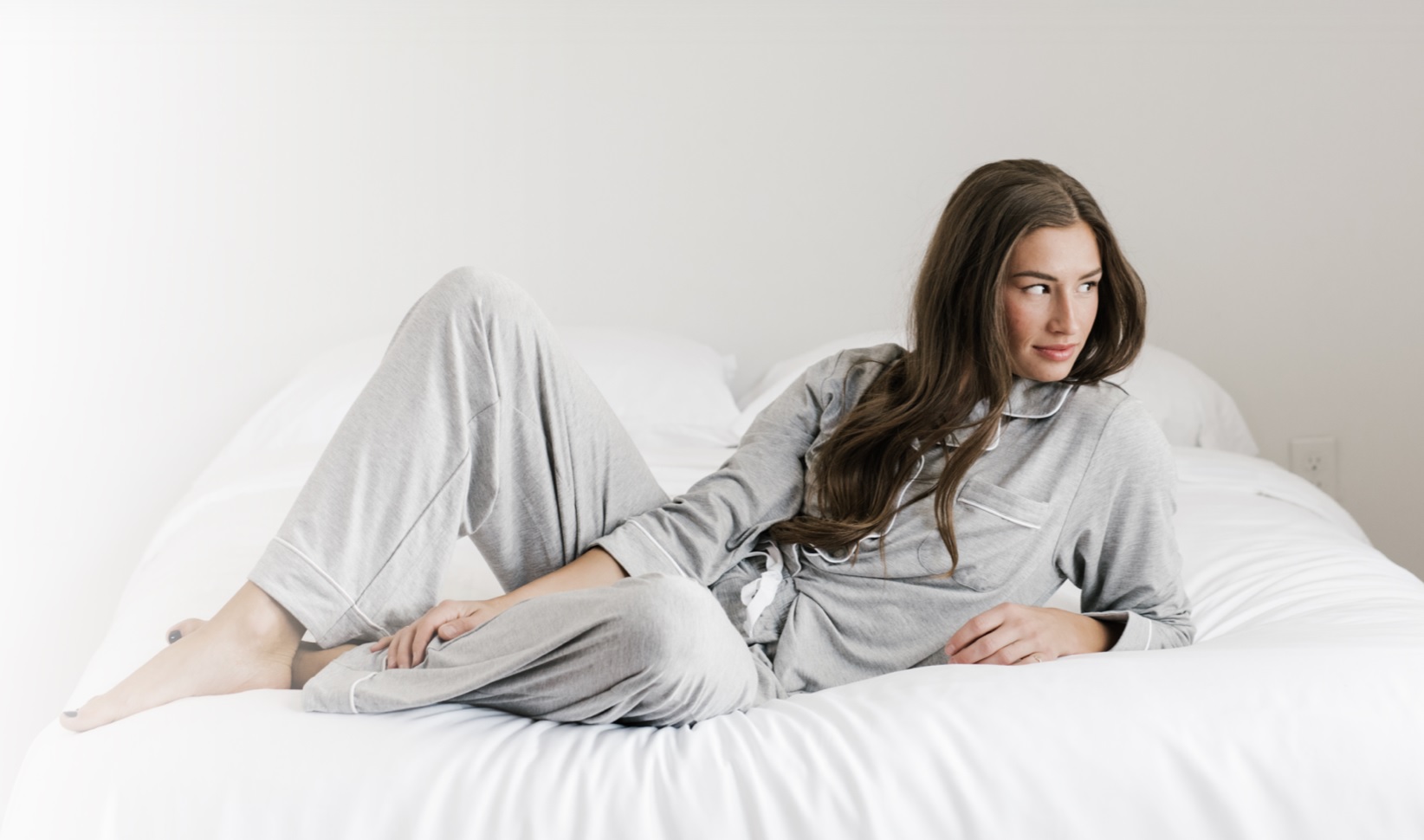 a woman wearing pajamas laying in bed