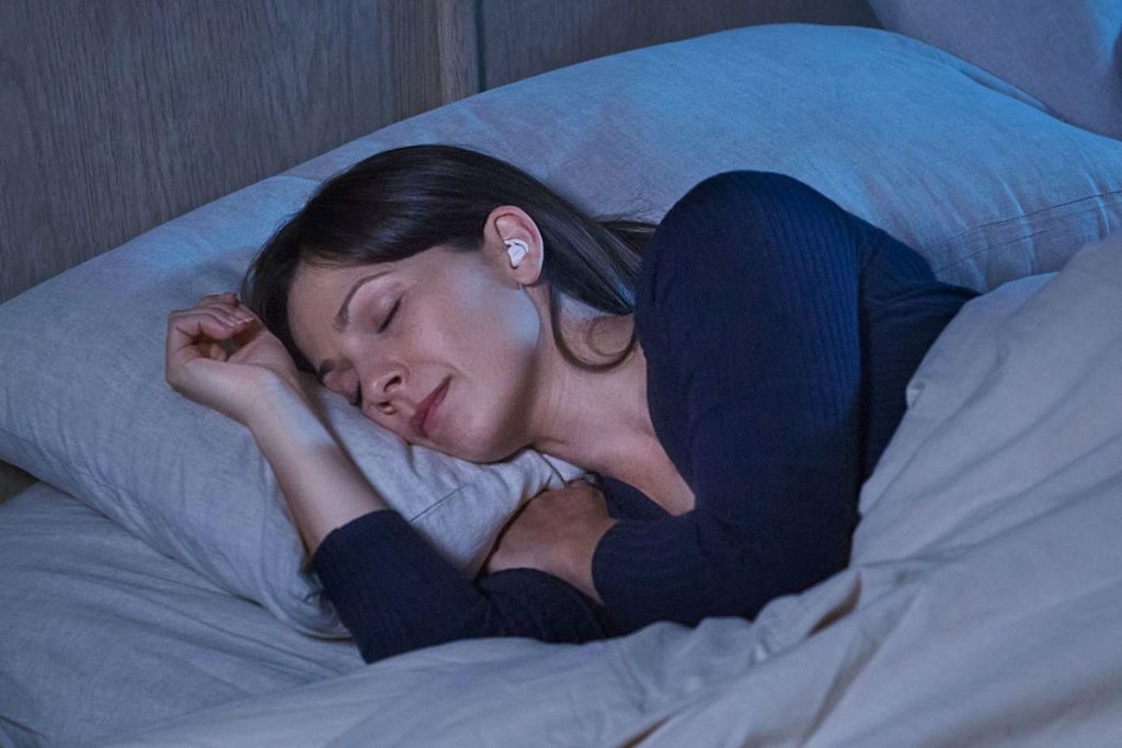 a woman sleeping with Bose Sleepbuds