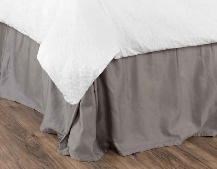 a messy and wrinkled bedskirt on a bed